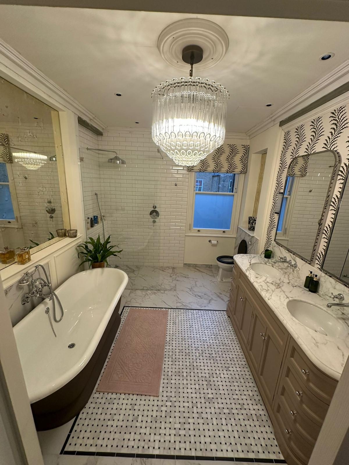 Full view of the bathroom with bath, shower and twin vanity