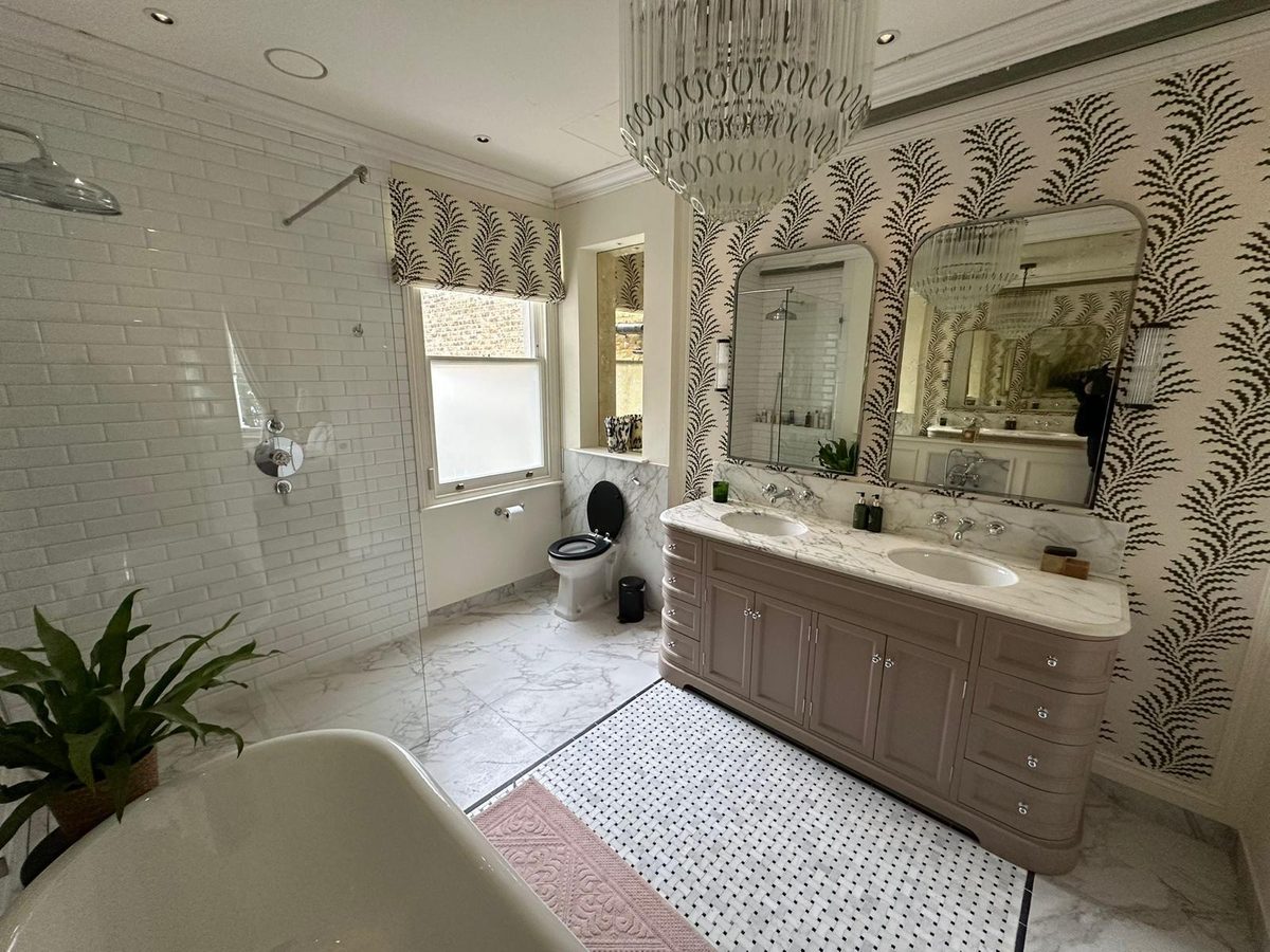 Roll-top bath in the foreground with vanity beyond