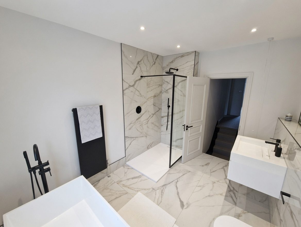 Walk-in shower and freestanding bath in marble