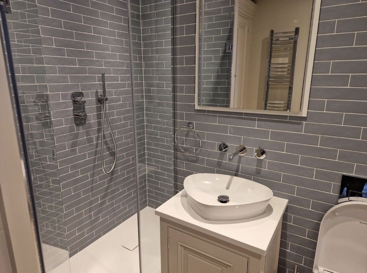 Walk-in shower and vessel basin in the grey en-suite